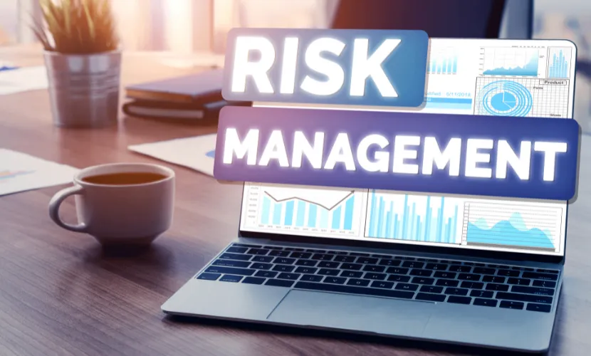 Laptop displaying financial charts with the words Risk Management highlighted on screen.