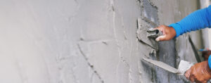 Worker plastering wall with cement for smooth finish – Best cement for plastering and application guide | Amrit Cement